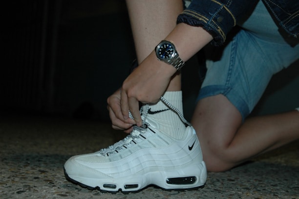 An athlete tying shoelaces on a pair of Stryke sneakers before a morning run.