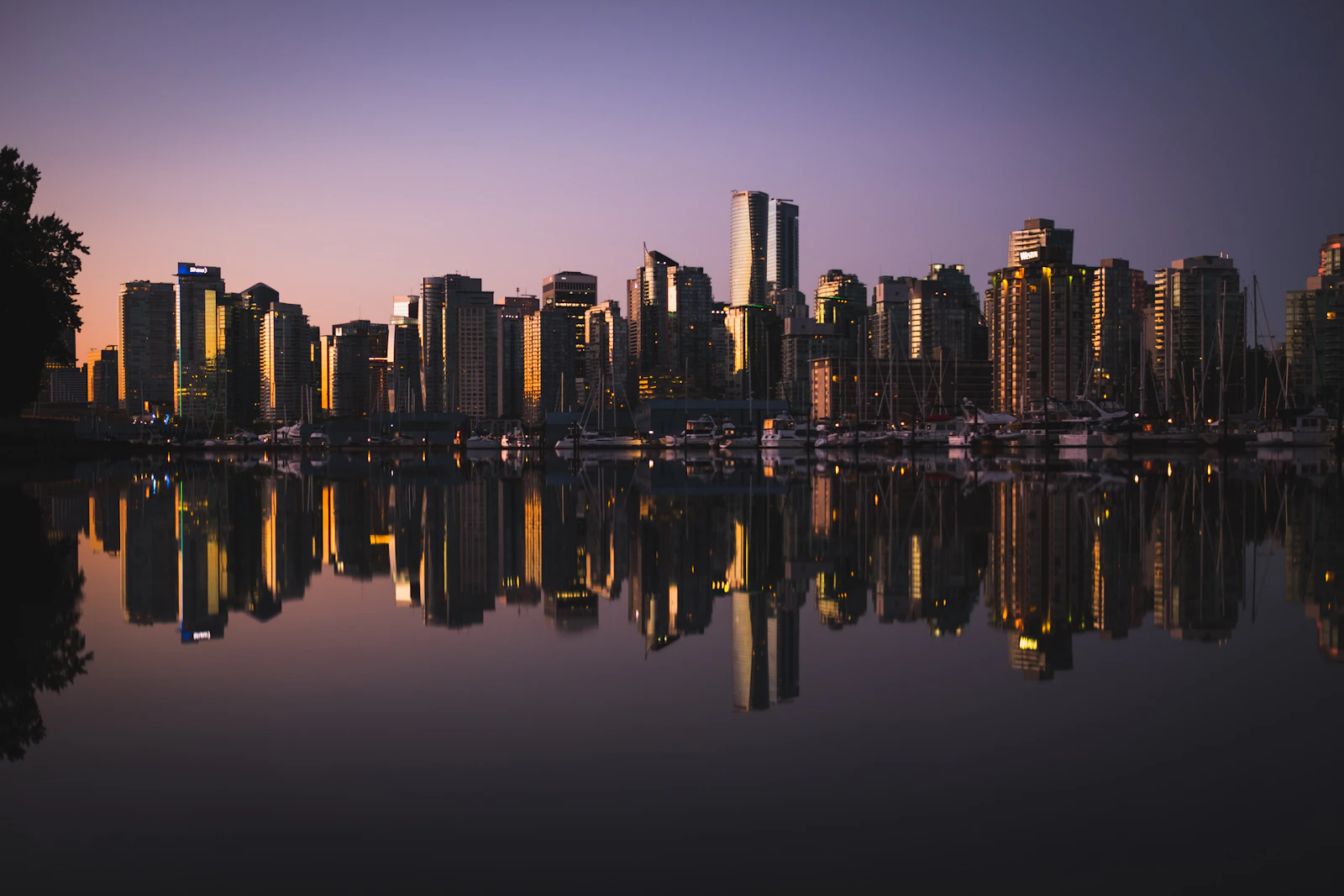 Vancouver skyline at dusk mirrored perfectly in the still water of Coal Harbour