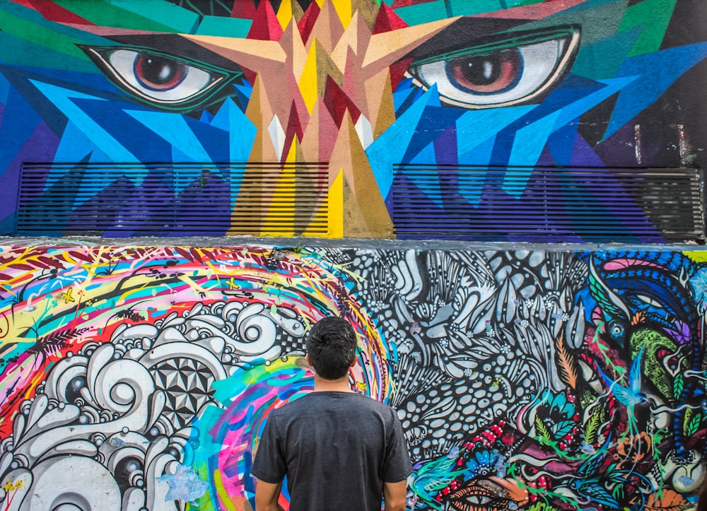 Fotografía de un hombre viendo el arte de la pared de Doddle