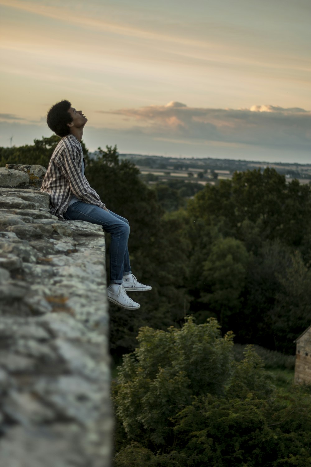 Mann sitzt auf grauer Betonklippe