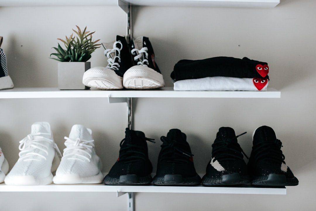 three pairs of black and white shoes on floating shelf