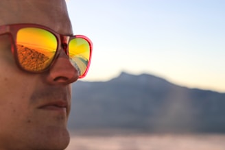 Lifestyle shot of a traveler wearing Lunnec glasses while capturing a scenic mountain view.