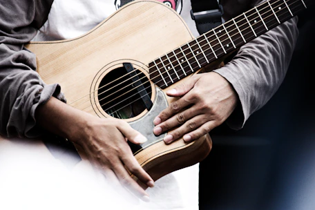 Close-up of hands playing an acoustic guitar during a worship session.