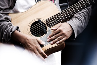 Close-up of a person playing an acoustic guitar indoors