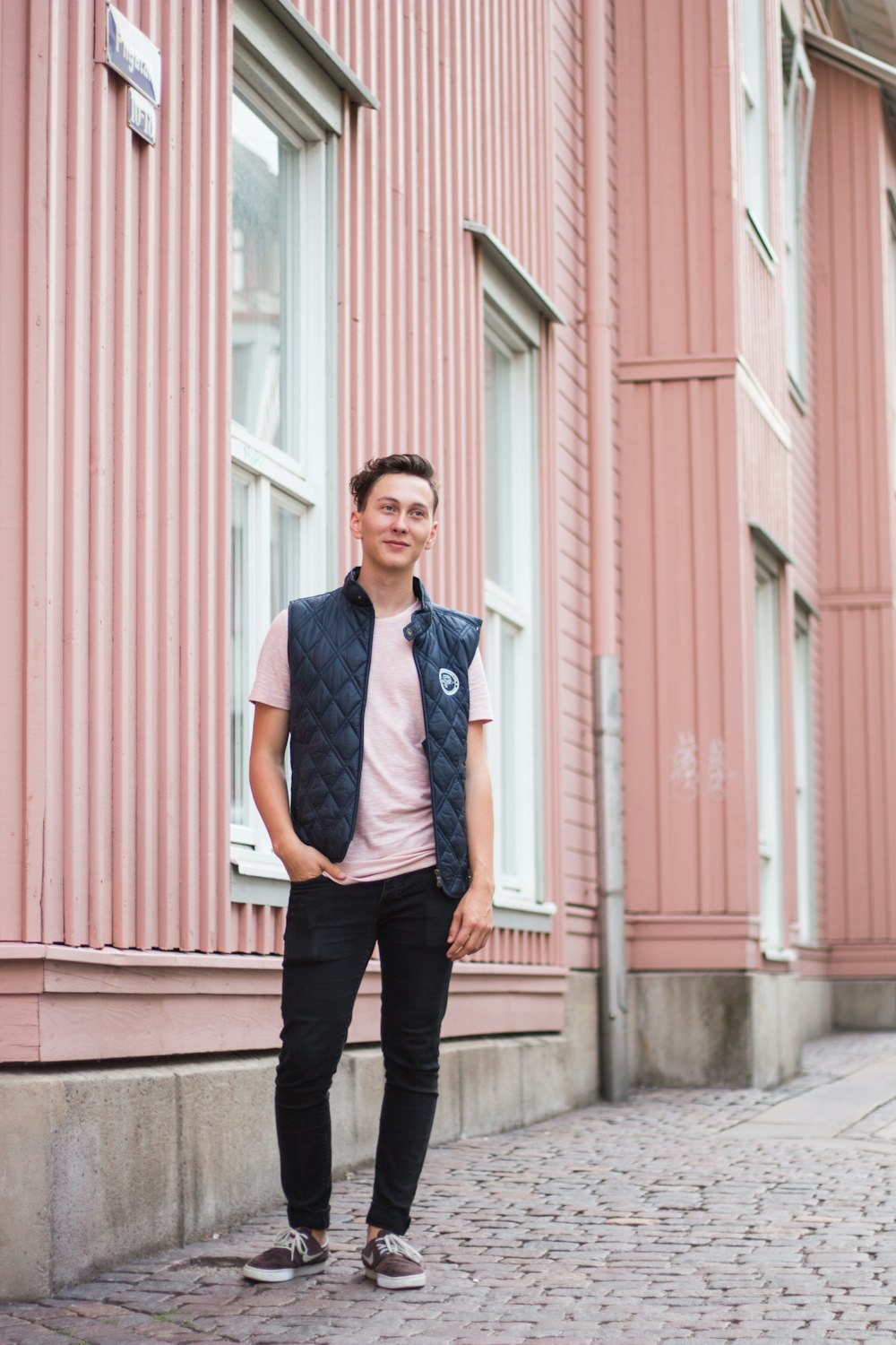 man standing beside building during day