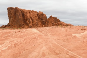 Tsingy Rouge’s striking red rock formations under a bright blue sky, with a 4x4 nearby.