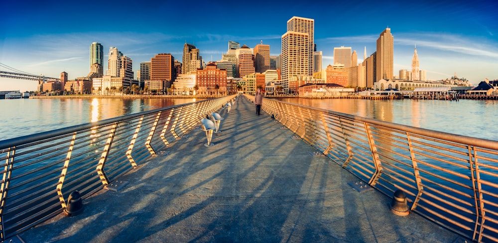 a person walking on a bridge over a body of water