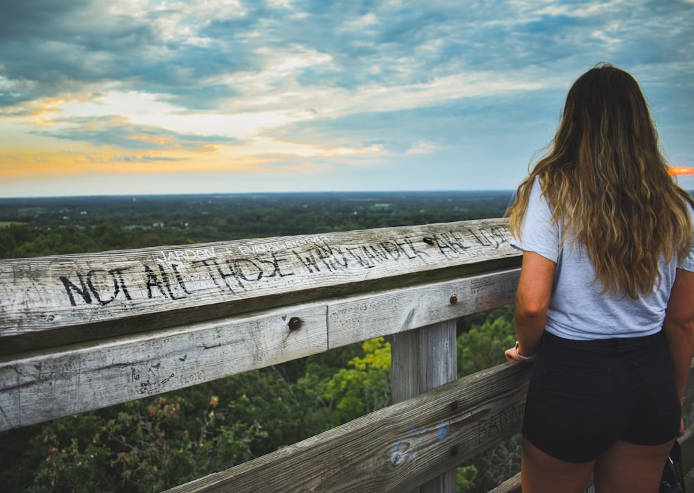 woman standing in front of wooden fence