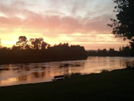 A quiet moment of reflection by a riverbank at sunset, where tradition meets nature’s calm.