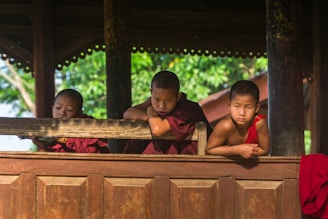 boys leaning on brown wooden board