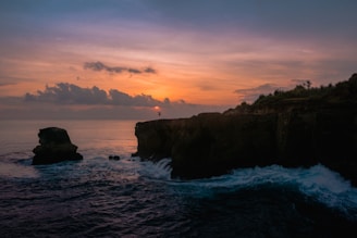 A vibrant photo of Negril's 7 Mile Beach at sunset with cliff jumpers at Rick's Cafe.