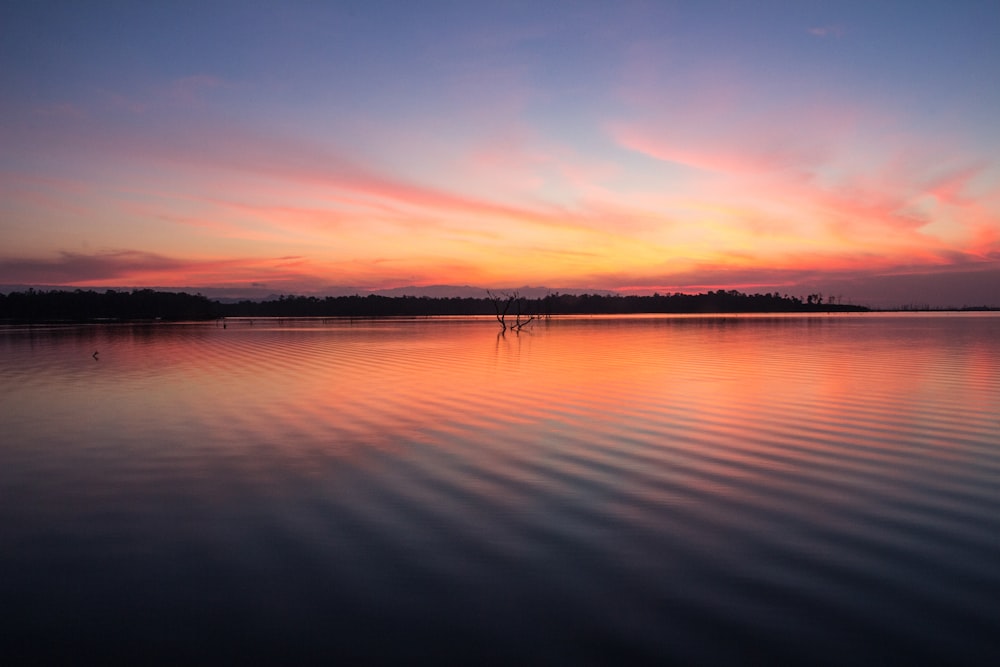 reflection of orange sky on still water