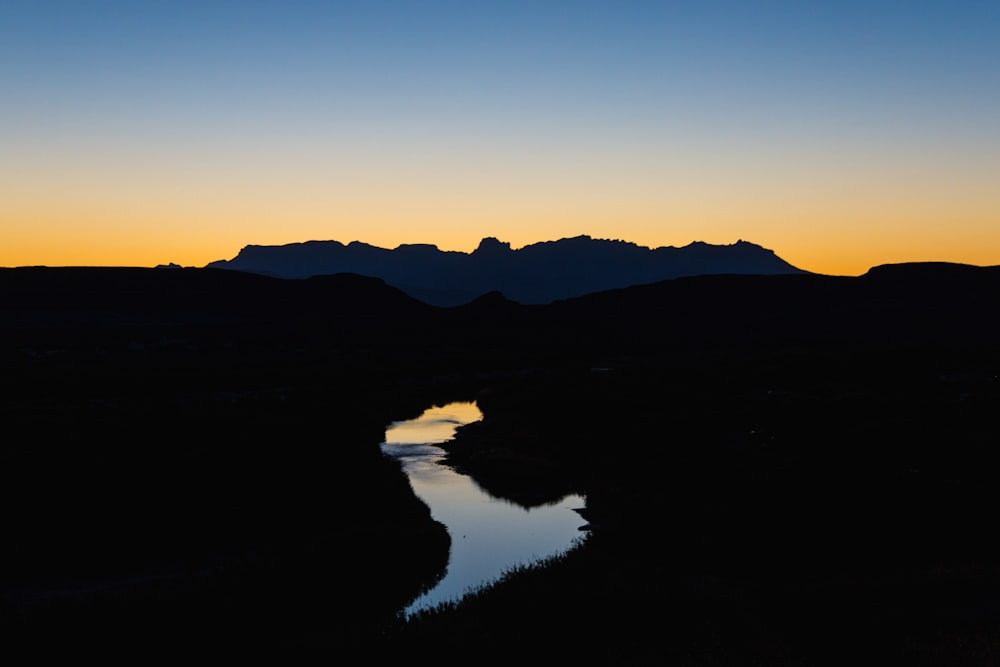 fotografia de paisagem do rio que leva à montanha