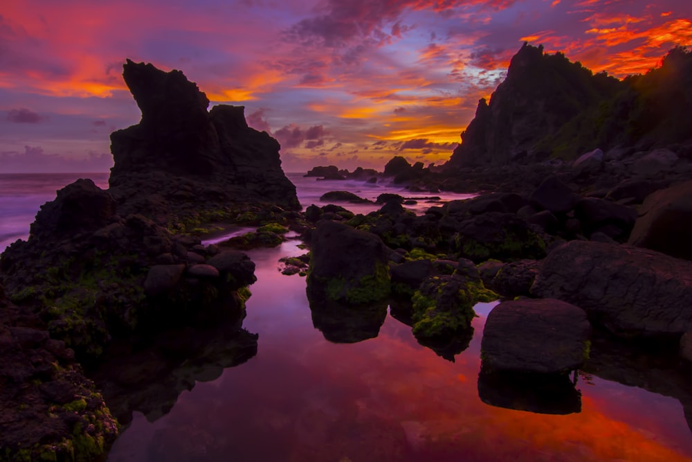 photo of rock formations under red sky