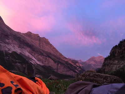 Sunset casting golden hues over rugged peaks as a group sets up camp in Pangi Valley.