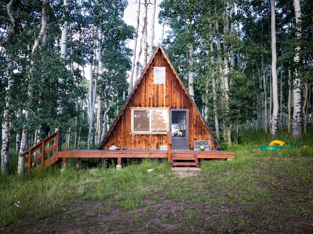 昼間の森の真ん中にある茶色の木造住宅