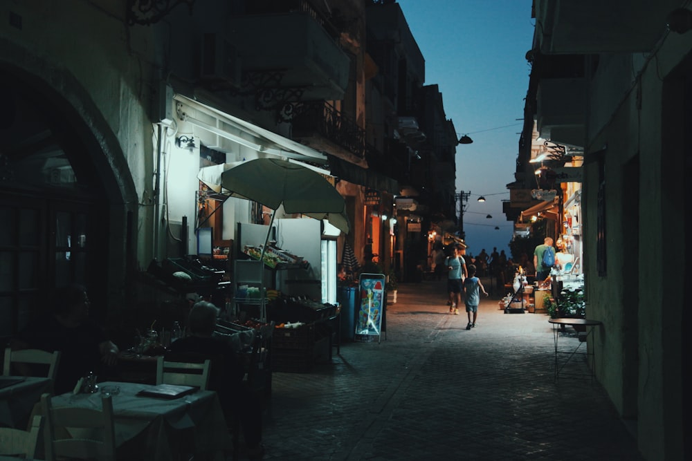 person walking near fruit lot at nighttime