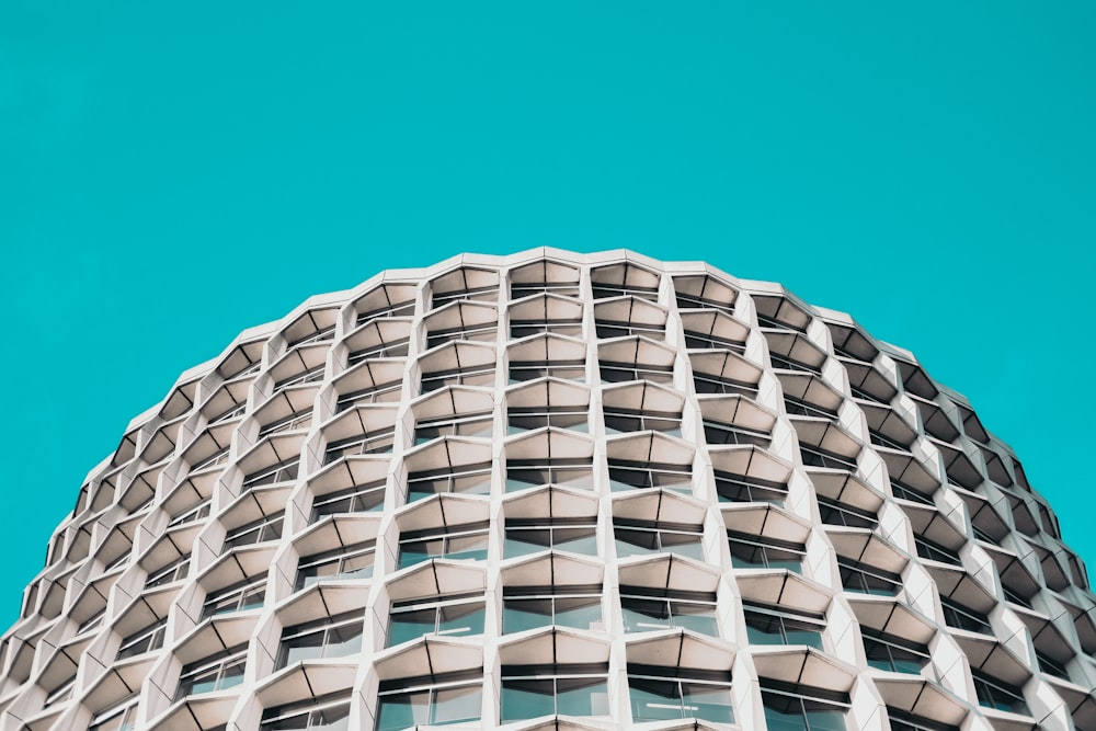 Photographie en contre-plongée d’un immeuble de grande hauteur en béton blanc