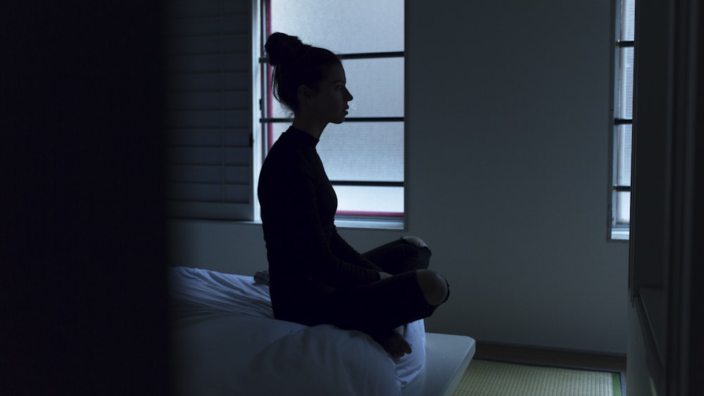 woman sitting on bed