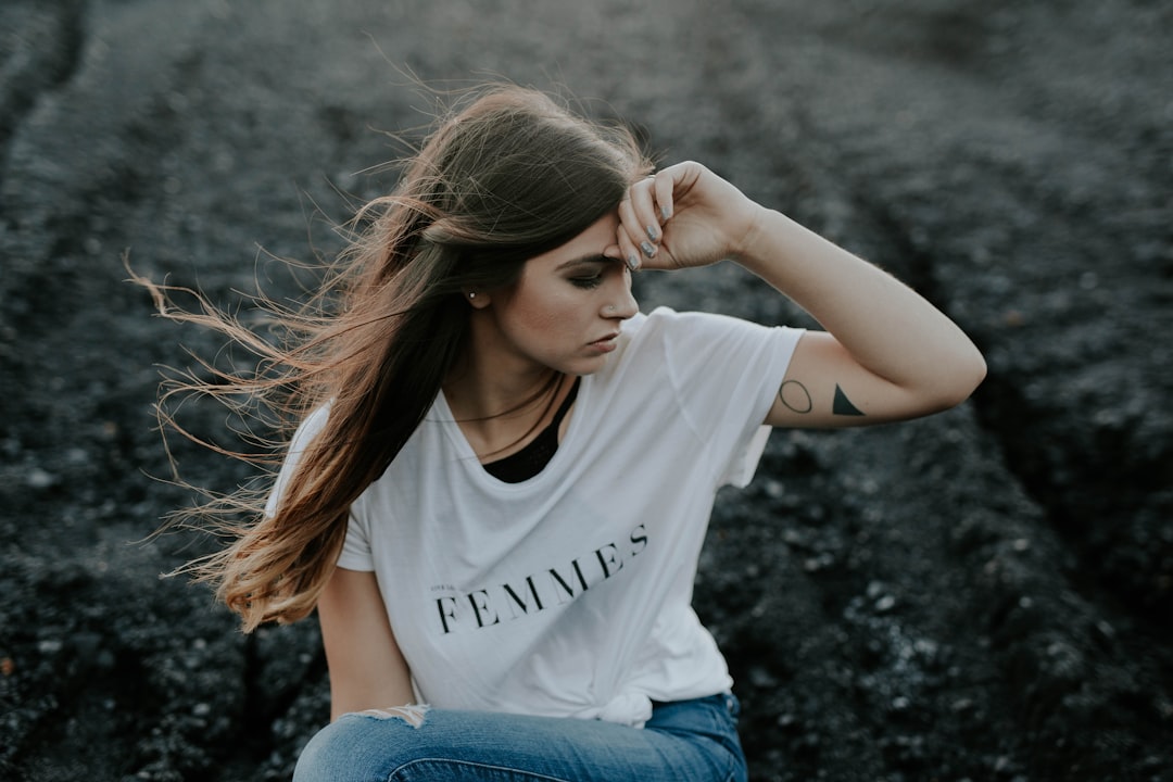 woman in white shirt sitting on ground