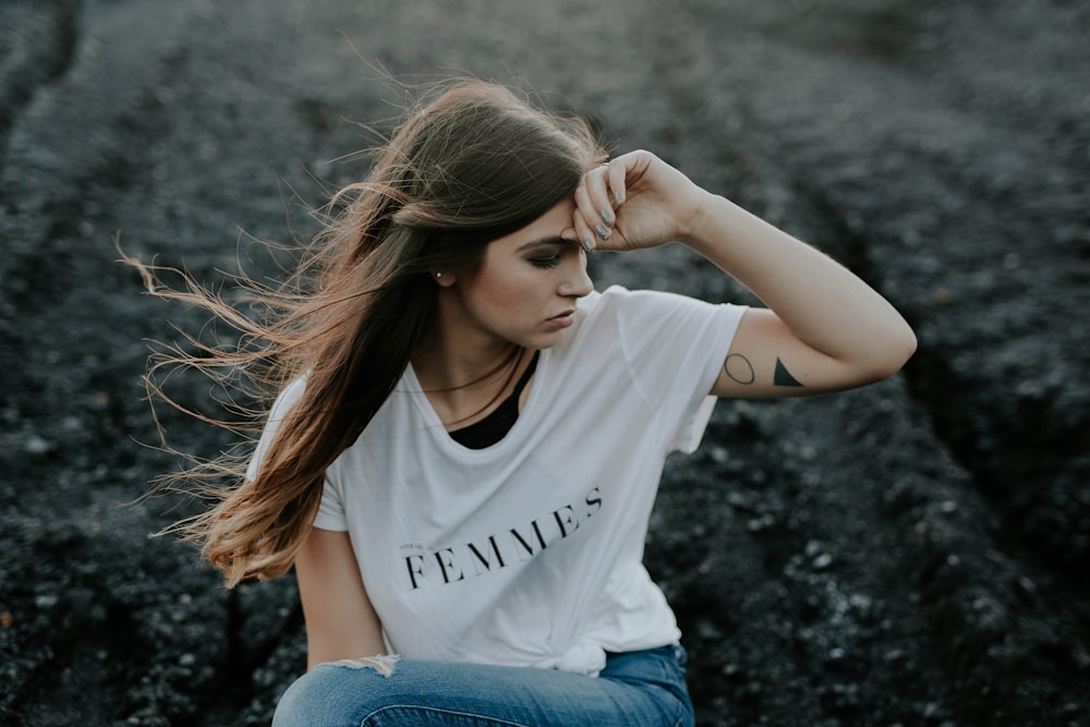 mulher na camisa branca sentada no chão