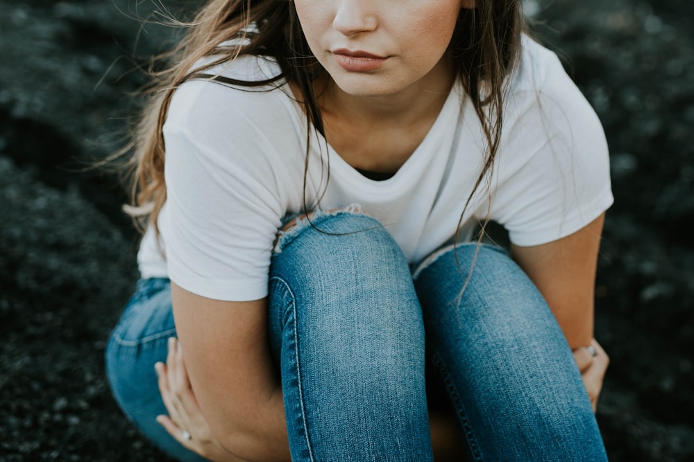 shallow focus photo of woman in white scoop-neck T-shirt and jeans