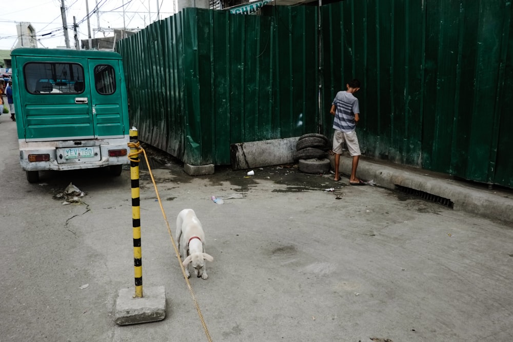 man peeing on sidewalk during daytime