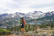 Hiker standing on a peak overlooking snow-capped Himalayan mountains.