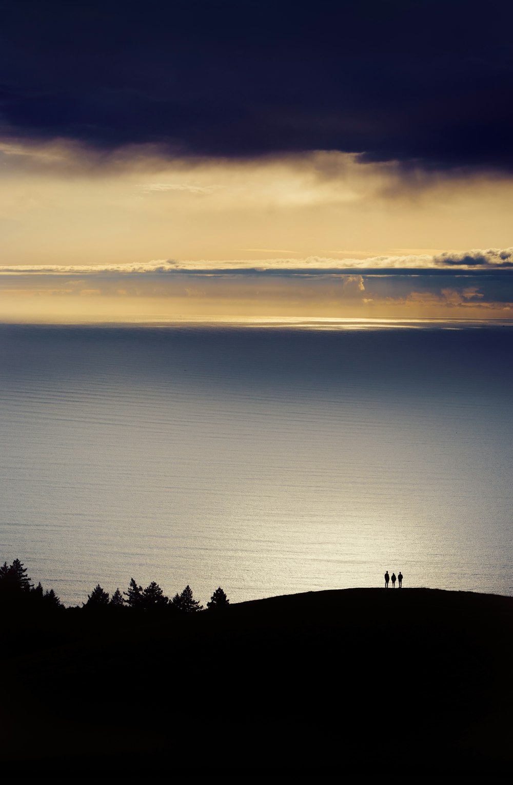 a couple of people standing on top of a hill