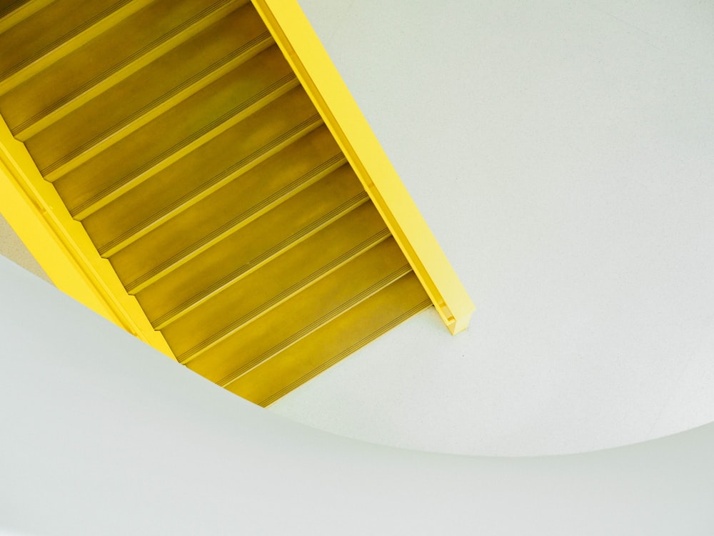 Un estante amarillo sentado encima de una pared blanca
