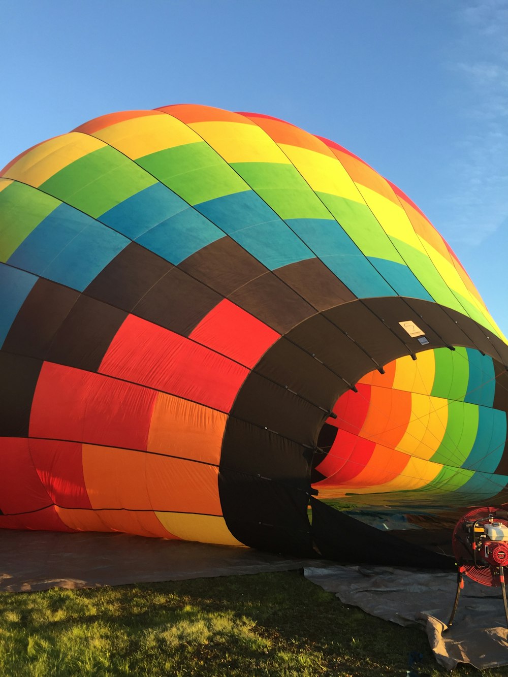 blue, green, and orange hot air balloon on grass field