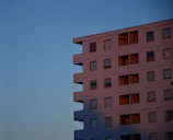 A pristine minimalist residential building with clean lines and large glass windows under soft twilight.