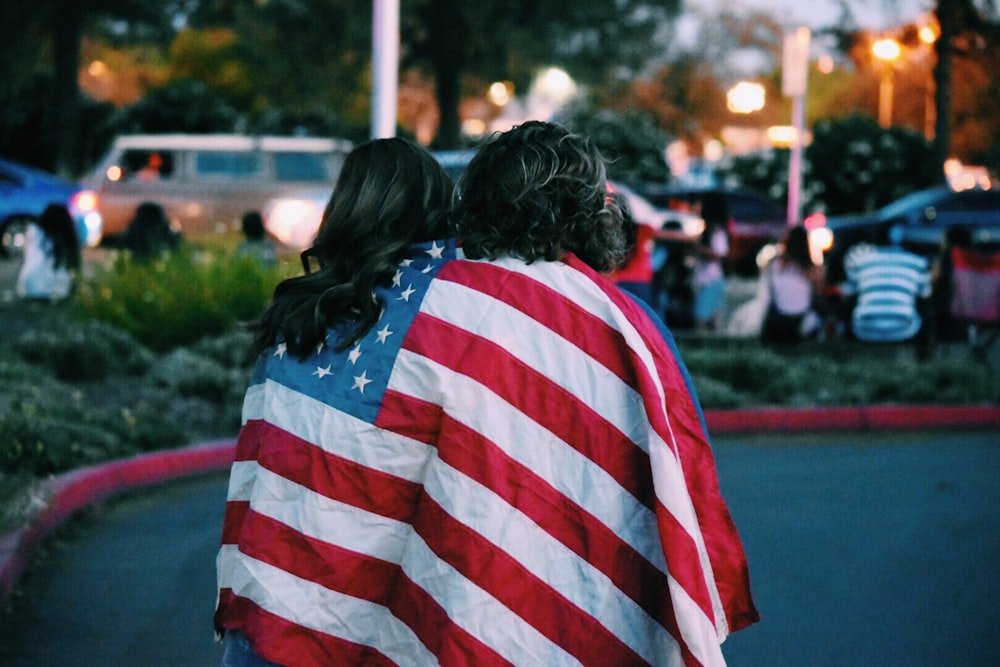 女性と男性がアメリカの国旗を覆った