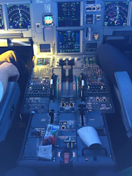 Pilot’s hands on controls inside a highly detailed flight simulator cabin.