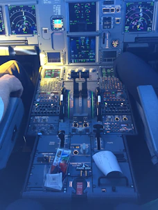 Pilot’s hands on controls inside a highly detailed flight simulator cabin.