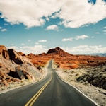 road under white and blue sky