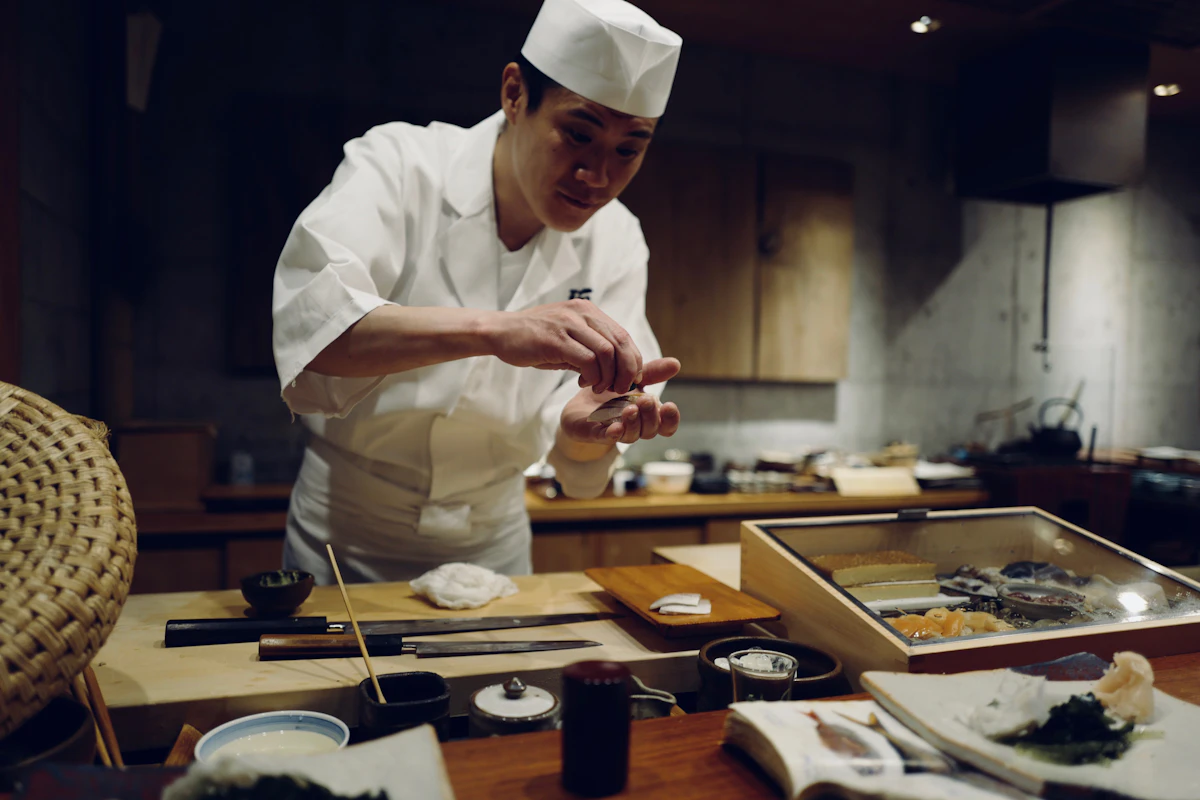 Sushi chef preparing nigiri behind the counter