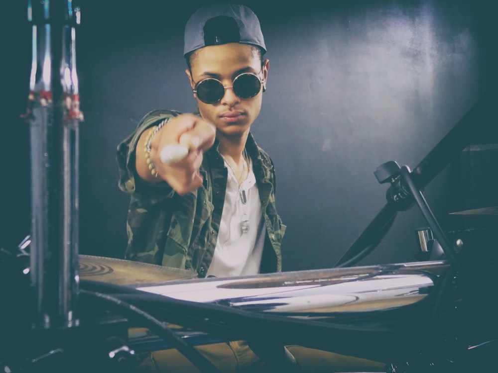 person holding drumstick seating in front of drum set