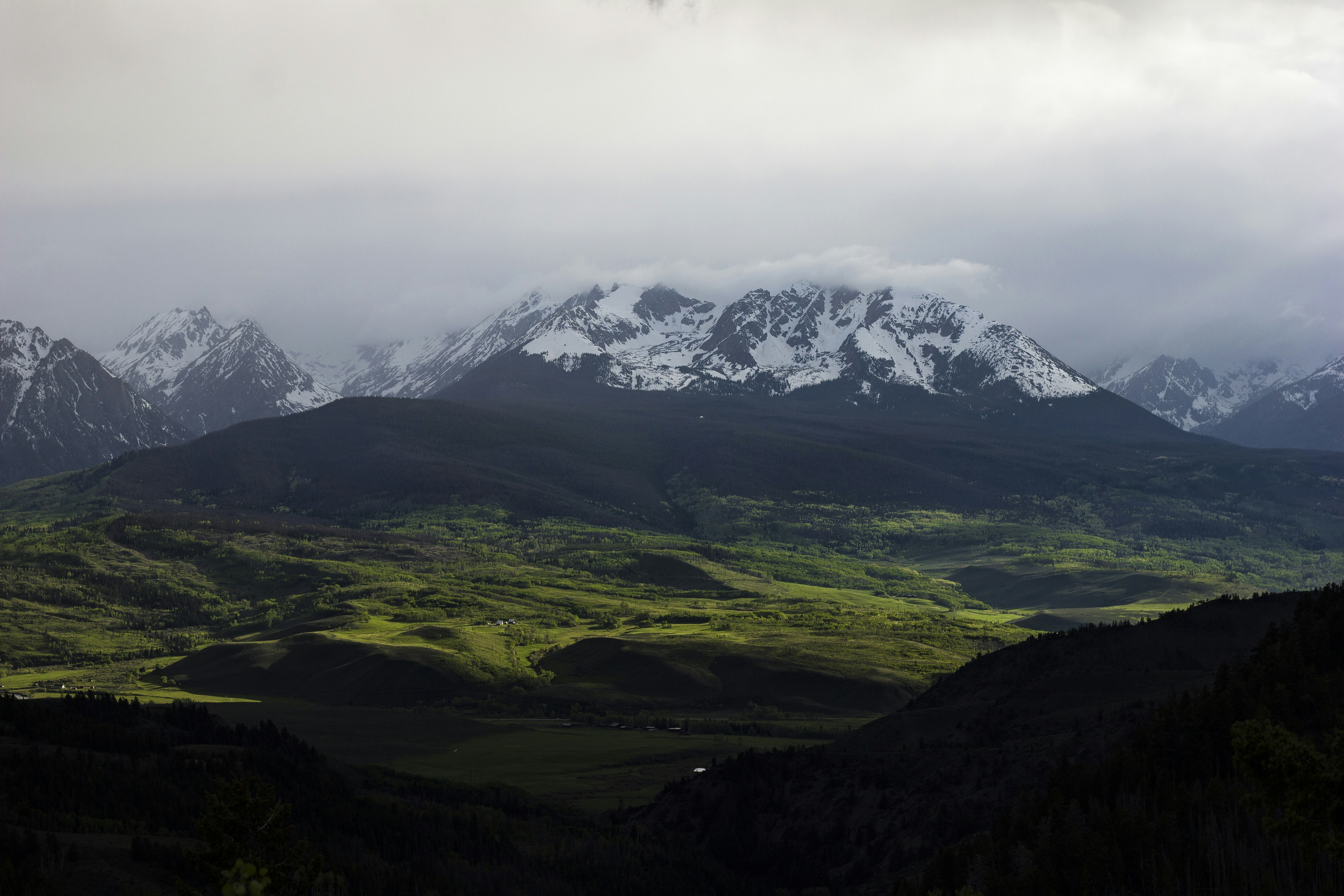 panoramic photo of glacier mountain above forest