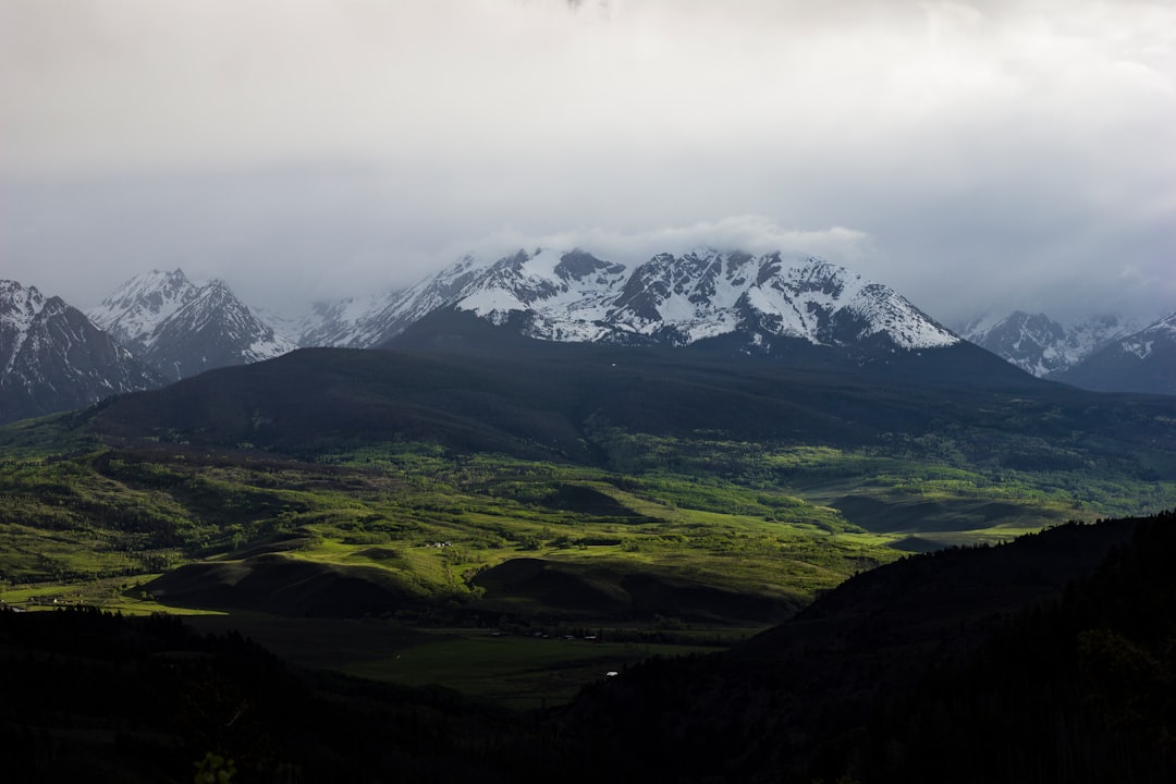 panoramic photo of glacier mountain above forest