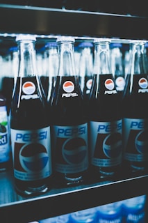 Popsico beverages displayed in a modern store shelf, highlighting the brand’s blue and water drop theme colors.