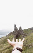 person pointing three gray rock formations