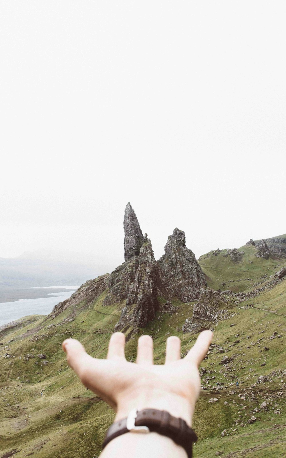 person pointing three gray rock formations