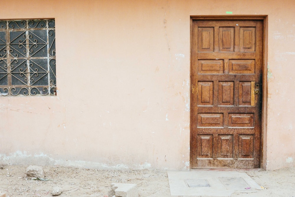 brown wooden door on white concrete wall