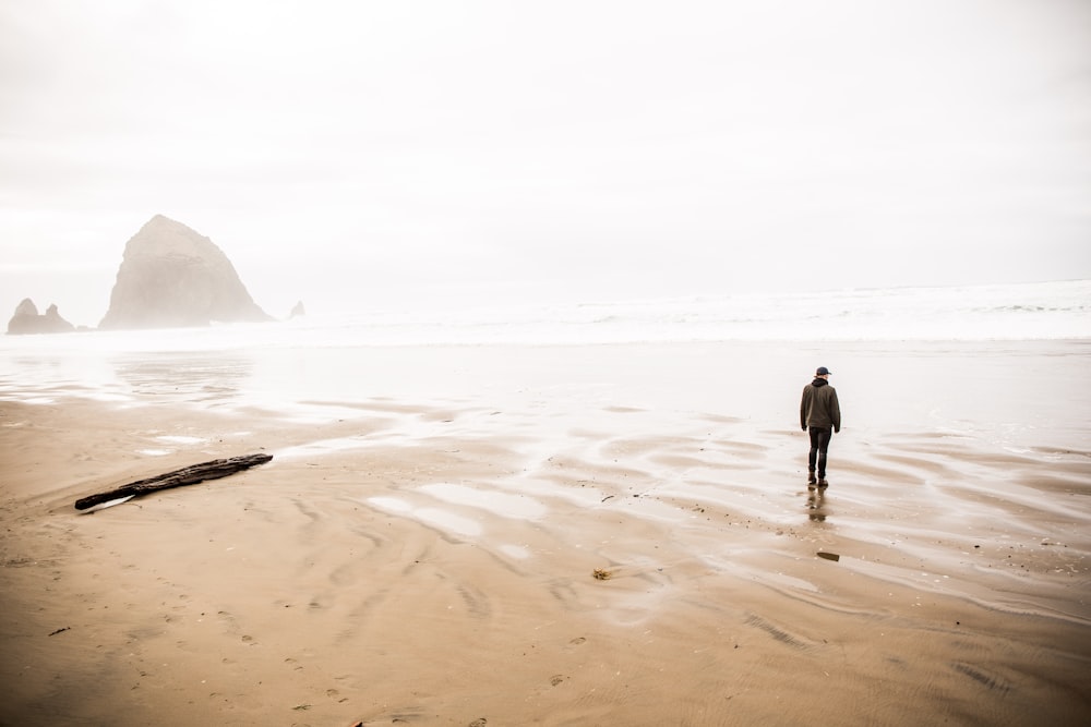 man walking on shore during daytime