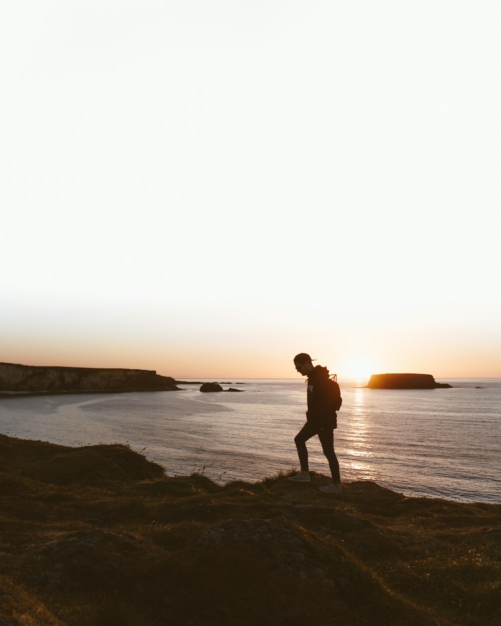 silhouette of man and woman walking on beach during sunset