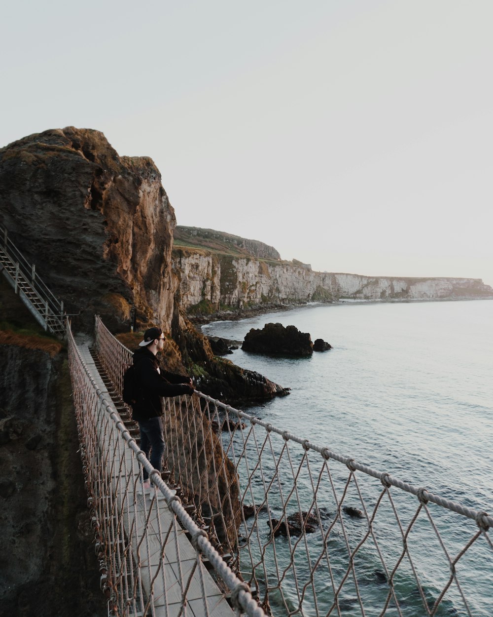 man standing on cable-stayed bridge