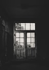 grayscale photo of wooden framed clear glass door