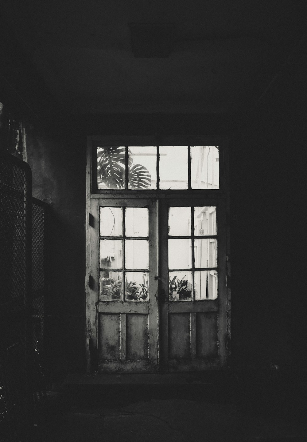 grayscale photo of wooden framed clear glass door