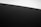 A minimalistic photograph capturing a sand dune with fine ripples under natural light. The horizon is slightly angled, creating a dynamic composition. The sky is clear and the sand appears almost black.